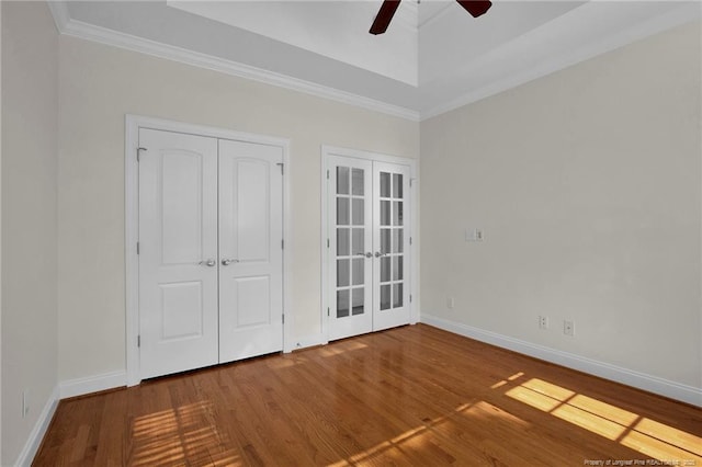 unfurnished room with wood finished floors, french doors, baseboards, and ceiling fan