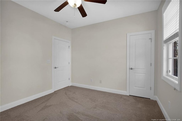 unfurnished room featuring baseboards, ceiling fan, and carpet flooring