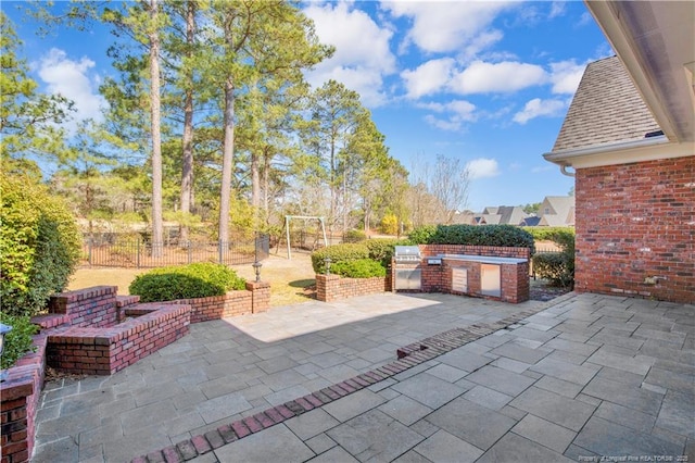 view of patio / terrace with exterior kitchen and fence