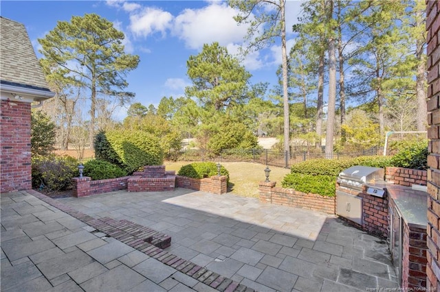 view of patio with grilling area, exterior kitchen, and fence