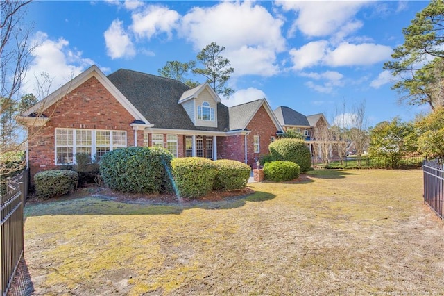 view of front of home featuring brick siding, a front yard, and fence