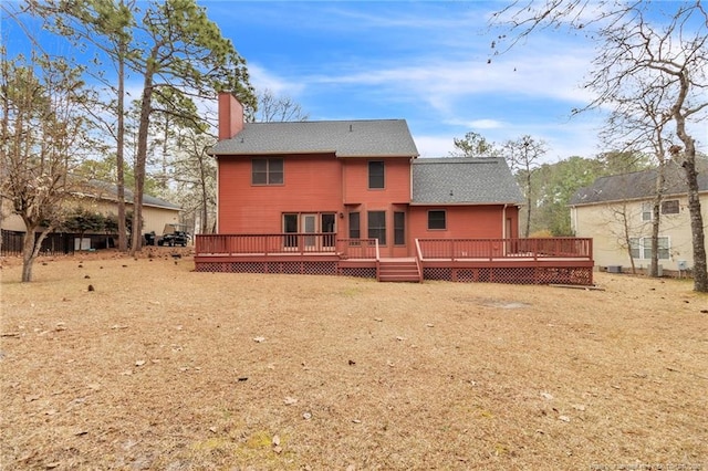 rear view of house with a deck and a chimney