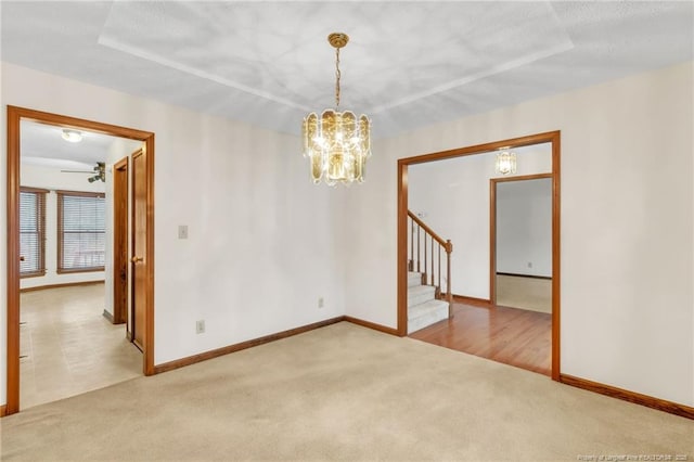 spare room with baseboards, carpet, a chandelier, and stairs