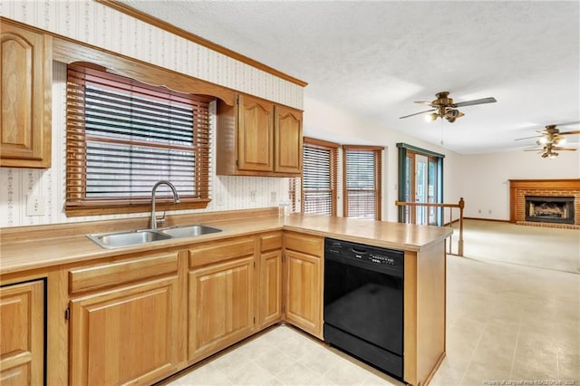 kitchen with a ceiling fan, wallpapered walls, a peninsula, a sink, and black dishwasher