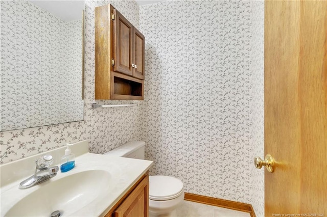 half bath featuring toilet, wallpapered walls, and vanity