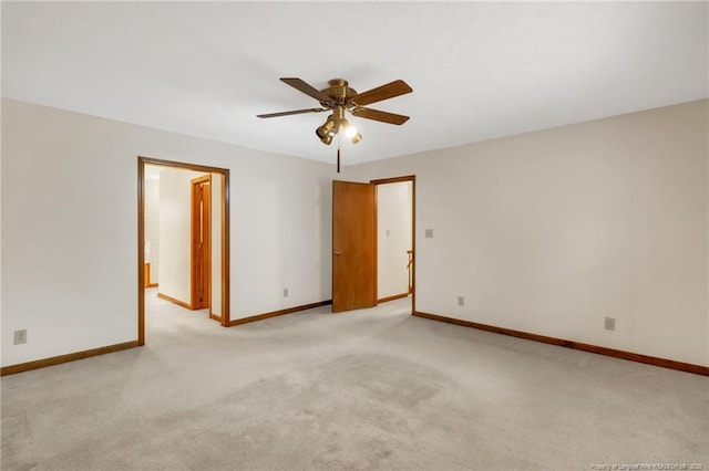 unfurnished room with baseboards, light carpet, and a ceiling fan