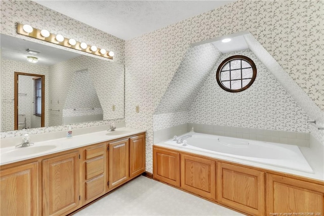 bathroom with a sink, a bath, and wallpapered walls