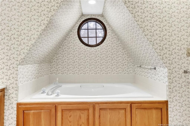 full bathroom with wallpapered walls, a bath, and vanity