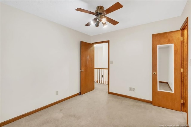 carpeted empty room featuring baseboards and a ceiling fan