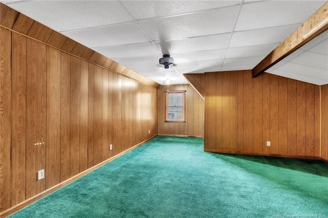 additional living space with beam ceiling, wooden walls, carpet flooring, and baseboards