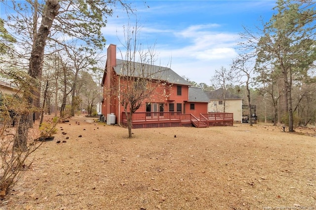 rear view of house with a chimney and a wooden deck