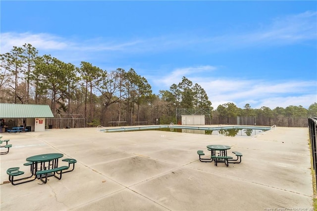 view of patio featuring a community pool and fence