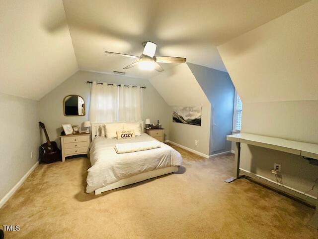 carpeted bedroom featuring visible vents, baseboards, ceiling fan, and vaulted ceiling