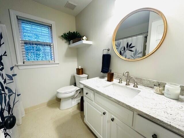 bathroom with visible vents, toilet, vanity, and baseboards