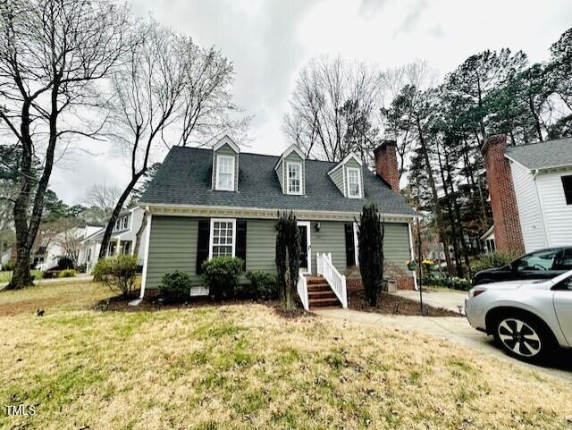 new england style home with a front lawn