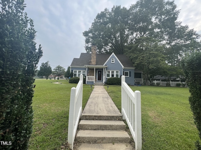 bungalow with a front lawn, fence, and a chimney