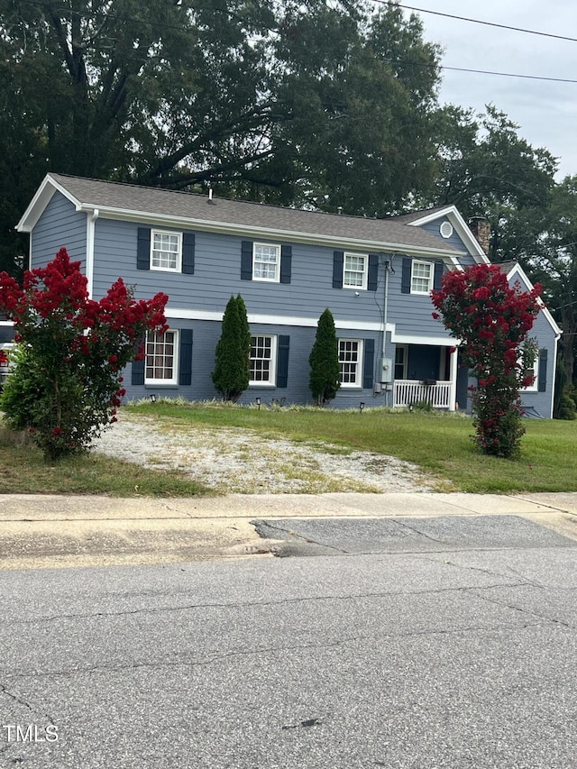 view of front of home featuring covered porch and a front lawn