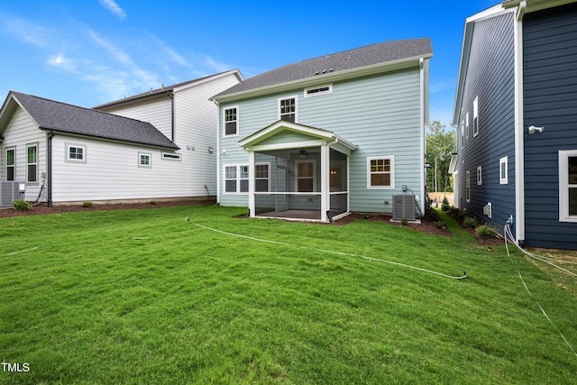 rear view of property with central air condition unit, a lawn, a ceiling fan, and a sunroom