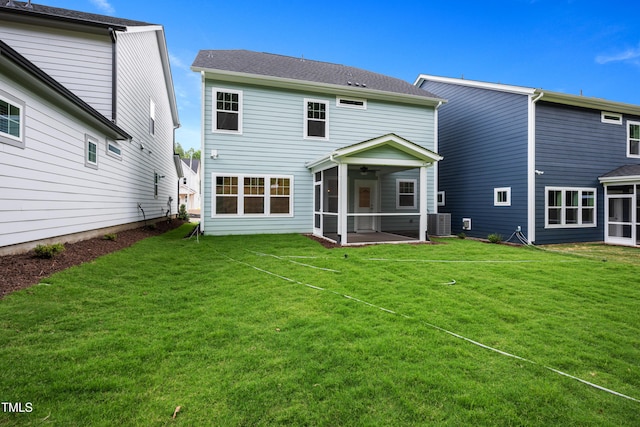 rear view of house featuring a yard, central AC unit, a ceiling fan, and a sunroom