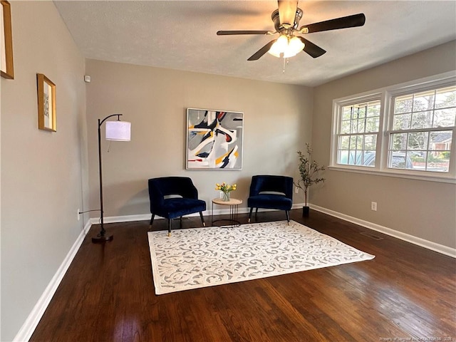 sitting room with a ceiling fan, baseboards, and wood finished floors