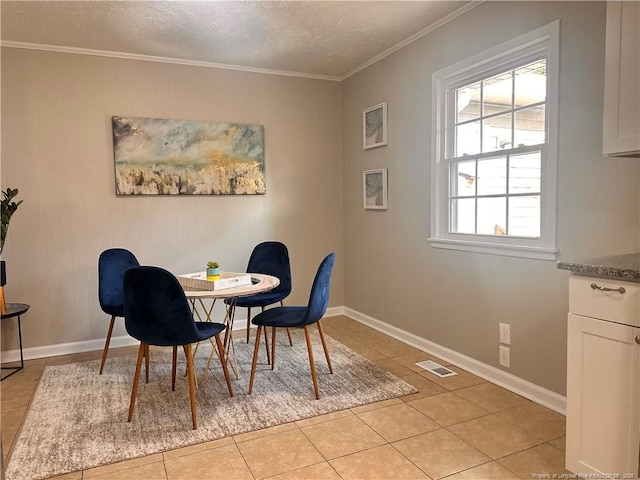 dining area featuring crown molding, light tile patterned floors, baseboards, and a textured ceiling