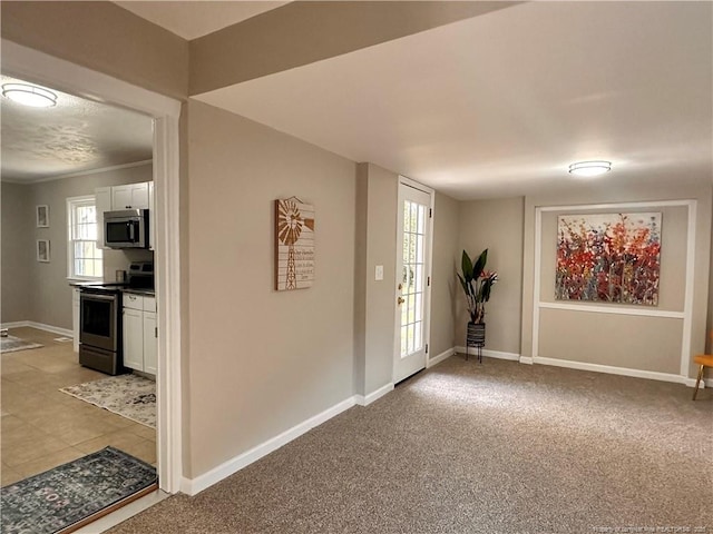 foyer featuring baseboards and light colored carpet