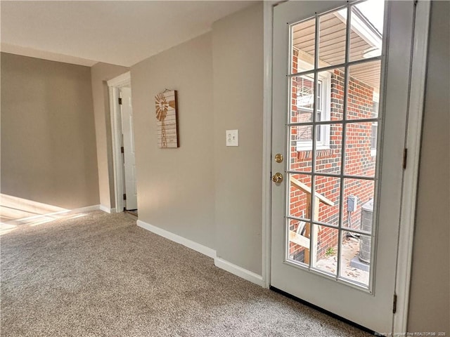 doorway with baseboards and carpet flooring