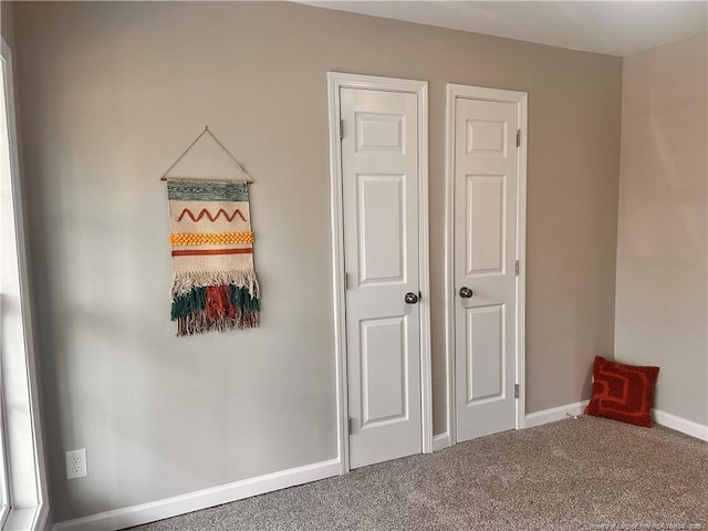 interior space featuring baseboards and carpet floors