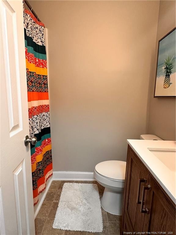 full bath featuring toilet, curtained shower, vanity, and baseboards