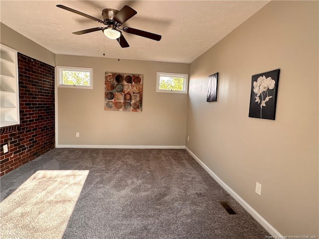 carpeted spare room with a healthy amount of sunlight, a textured ceiling, and ceiling fan