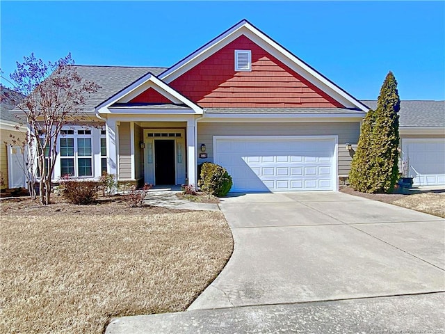 view of front of home featuring concrete driveway, an attached garage, and a shingled roof