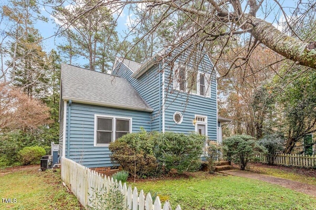 view of side of property featuring roof with shingles and central AC unit