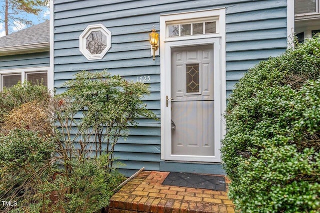 entrance to property with a shingled roof