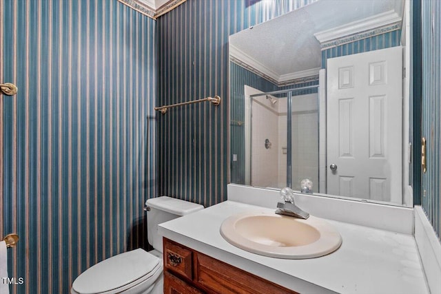 full bath featuring wallpapered walls, toilet, vanity, tiled shower, and crown molding