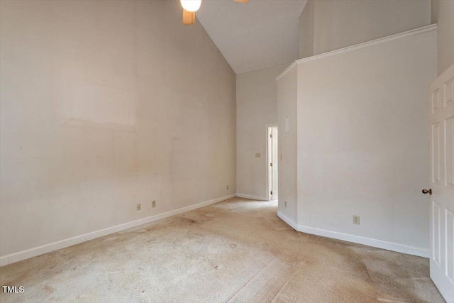 unfurnished room with carpet, a ceiling fan, baseboards, and high vaulted ceiling