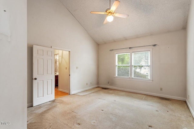 carpeted empty room with a textured ceiling, high vaulted ceiling, baseboards, and ceiling fan