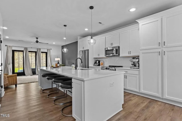 kitchen featuring visible vents, appliances with stainless steel finishes, wood finished floors, and white cabinets