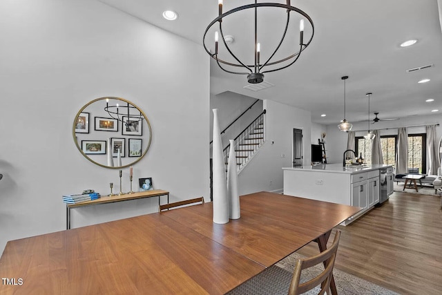 dining room with visible vents, recessed lighting, stairs, and wood finished floors