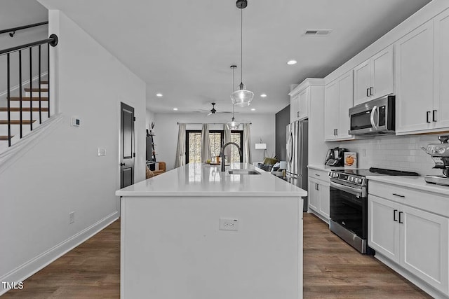 kitchen featuring a sink, dark wood-style floors, tasteful backsplash, and stainless steel appliances