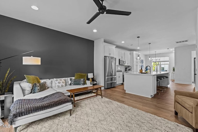 living area with visible vents, baseboards, recessed lighting, dark wood-style floors, and a ceiling fan