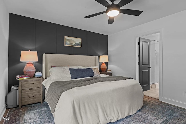 bedroom featuring a decorative wall, baseboards, and ceiling fan