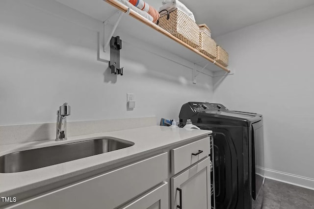 laundry room featuring baseboards, cabinet space, independent washer and dryer, and a sink