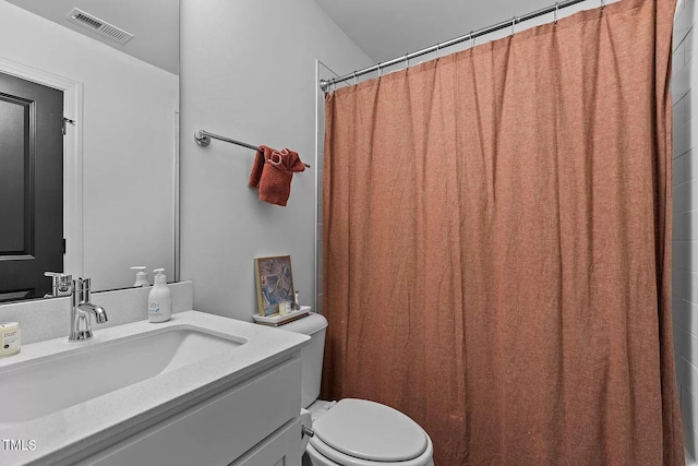 bathroom featuring visible vents, toilet, vanity, and a shower with shower curtain