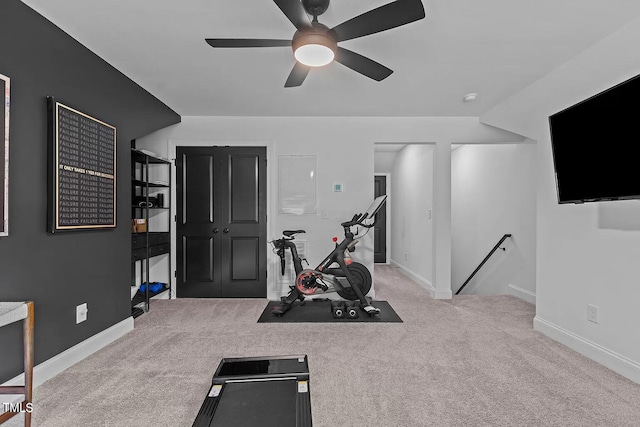 workout room with baseboards, ceiling fan, and carpet floors