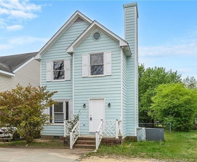 view of front of home featuring crawl space and a chimney