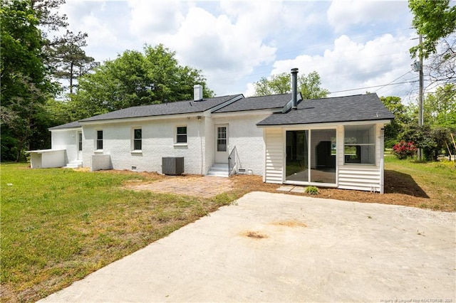 rear view of house with central AC unit, a yard, entry steps, brick siding, and a shingled roof