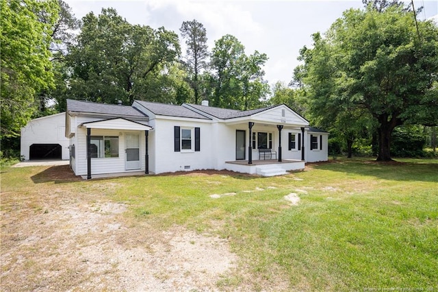 back of property with a porch, a yard, dirt driveway, and view of scattered trees