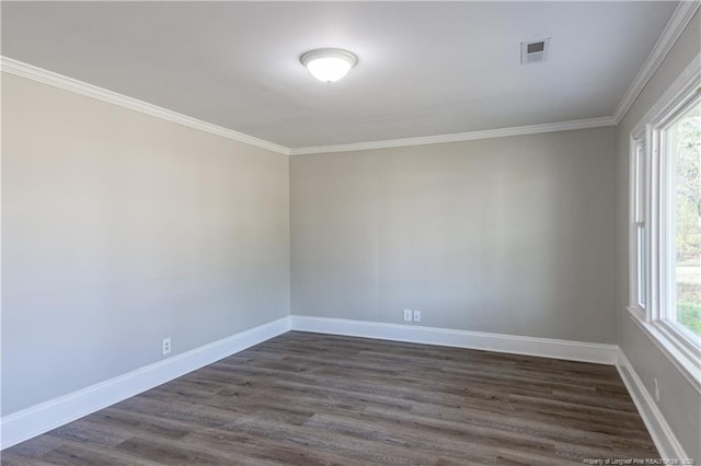 empty room with ornamental molding, dark wood-style floors, and baseboards