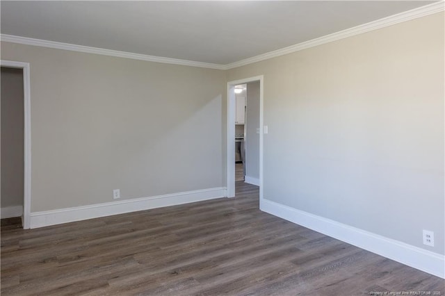 spare room featuring dark wood-style flooring, baseboards, and crown molding