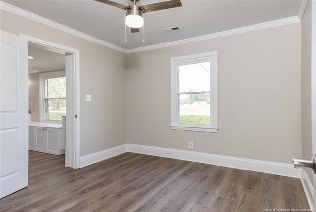 unfurnished room with wood finished floors, ceiling fan, crown molding, and baseboards